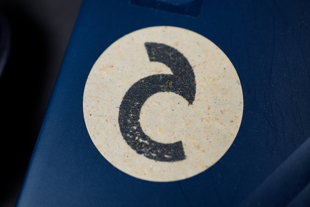 A Sticker Made Of Grass Paper With A Logo Stamp On It As Part Of The Brand Identity Design For Corliss Design