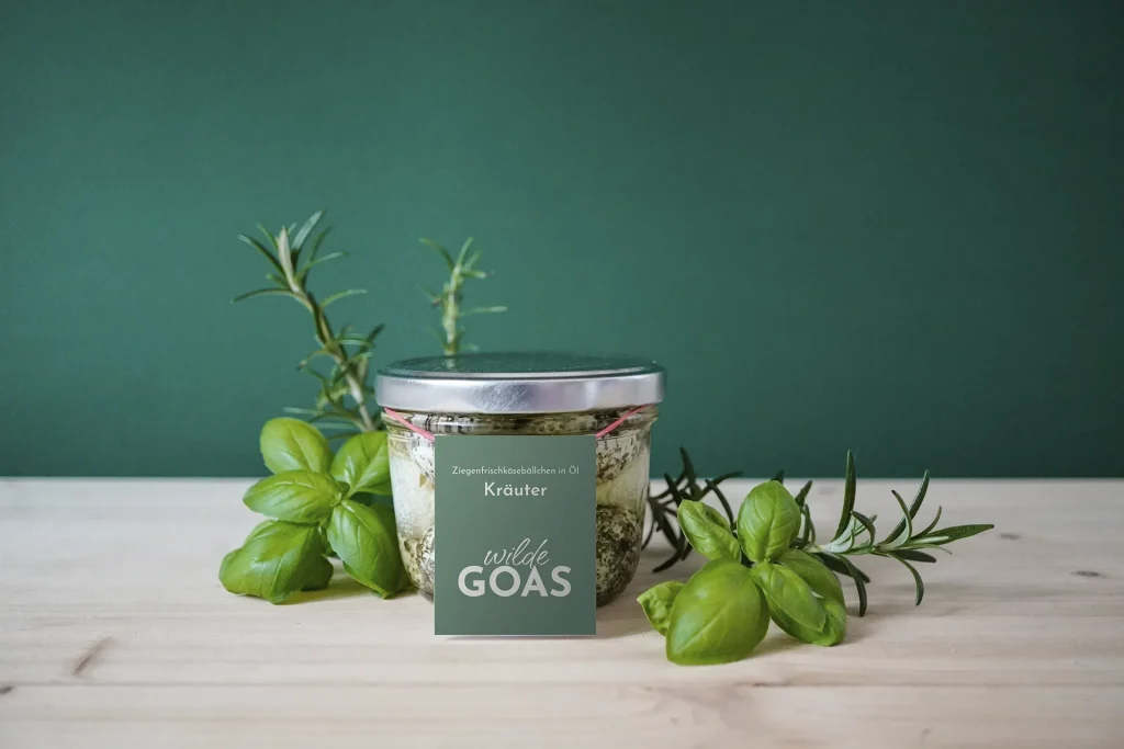 Brand Design von Corliss Design für wilde GOAS, zu sehen ist ein Glas mit Ziegenkäsebällchen und einem Etikett