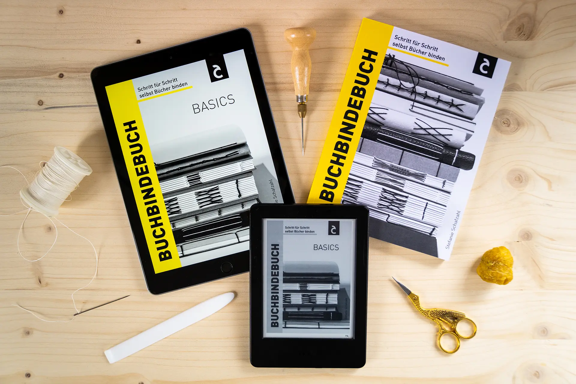 Editorial Design für Buchbindebuch von Stefanie Schafzahl-Corliss Design, zu sehen sind das Buchbindebuch in Printform sowie das Buchbindebuch Basics am Tablet und Kindle