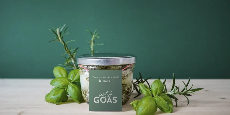 Brand Design von Corliss Design für wilde GOAS, zu sehen ist ein Glas mit Ziegenkäsebällchen und einem Etikett